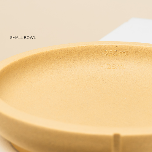 En lille gul hundeskåle, hvor der er plads til 2,5 dl. Den passer til de allermindste hunderacer.